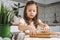 Portrait little studiously girl, learning rolling dough, making shape easter pastry. Holding rolling pin flour. Closeup