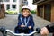 Portrait of little toddler girl with security helmet on the head sitting in bike seat and her father with bicycle. Safe