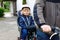 Portrait of little toddler girl with security helmet on the head sitting in bike seat and her father with bicycle. Safe