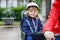 Portrait of little toddler girl with security helmet on the head sitting in bike seat and her mother with bicycle. Safe