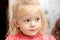 Portrait of a little two-year-old blond girl with a focused gaze