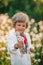 Portrait of little ukrainian boy with dandelion in spring garden. Child in traditional embroidery vyshyvanka shirt