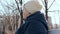 Portrait of a lonely depressed elderly senior woman sitting on a bench in city park in early spring in sunny day -