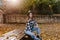 Portrait of lonely girl with sad smile sitting in park surrounded by golden leaves. Outdoor photo of stunning caucasian