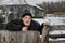 Portrait of lonely Ukrainian old man with tearful face standing at his fence near neglected house in rural Ukrainian village