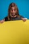 Portrait of long haired man making a funny face while holding a blue advertise banner