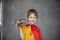 Portrait looking at the camera Dreamy boy in a red cape plays with a toy airplane