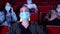 Portrait of a lovely blond girl with bright makeup wearing safety mask visiting cinema. Media. Young woman watching