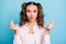 Portrait of lovely brown-haired girl sending air kiss showing count gesture isolated over bright blue color background