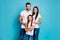 Portrait of lovely family looking with toothy smile wearing white t-shirt denim jeans isolated over blue background