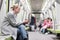 Portrait of lovely girl typing message on mobile phone in almost empty public subway train. Staying at home and social