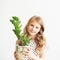 Portrait of a lovely little girl with green houseplant