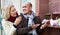 Portrait of loving mature couple feeding birds in cage