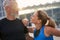 Portrait of loving mature couple, sporty man and woman having morning workout in the city on a summer day