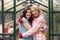 Portrait Of Loving Same Sex Mature Female Couple Hugging As They Garden In Greenhouse Together