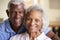 Portrait Of Loving Senior Couple Sitting On Sofa At Home Together