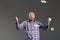 Portrait of lucky handsome middle-aged man in plaid shirt waving hands shouting over grey background with money falling