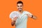 Portrait of lucky rich brunette man pointing at dollar banknotes. indoor studio shot isolated on orange background