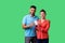 Portrait of lucky young couple in casual clothes satisfied with home purchase, mortgage. isolated on green background