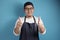 Portrait of male Asian chef or waiter shows thumbs up gesture, proud confident chef shows OK sign