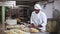 Portrait of male baker working with dough and forming baguettes