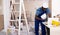 Portrait of a male builder who checks work done using a laptop