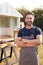 Portrait Of Male Carpenter Building Outdoor Summerhouse In Garden