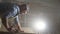 Portrait male carpenter in shirt in dark workshop planing wood