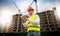 Portrait of male construction engineer standing on building site and using digital tablet