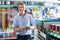 Portrait of male customer selecting paint can in housewares department