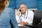 Portrait male doctor in conversation through telephone at clinic