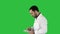 Portrait of male doctor walking and using digital tablet on a green screen, chroma key.