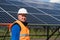 Portrait of male electrical engineer on the background of solar panels at a power plant.