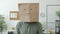 Portrait of male employee wearing paper bag with smile emoji standing in office and looking at camera