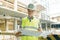 Portrait of male engineer at construction site. Builder looks at the plan of the construction site. Building, development, teamwor