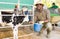 Portrait of male farm worker feeding calves