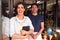 Portrait Of Male And Female Owners Of Florists With Digital Tablet Standing In Doorway With Plants