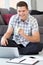 Portrait Of Male Freelance Worker Using Laptop At Home