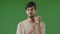 Portrait of male frustrated indian hispanic guy young man standing over green background waiting for meeting angry