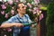 Portrait of a male gardener using trimming shears, is pruning shrubs and hedge, tending plants in the mansion backyard