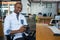 Portrait of male graphic designer holding digital camera at desk