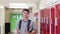 Portrait Of Male High School Student Walking Down Corridor And Smiling At Camera