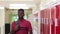 Portrait Of Male High School Student Walking Down Corridor And Smiling At Camera