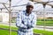 Portrait of male hired worker in greenhouse where flowers are grown