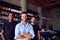 Portrait Of Male Owner Of Restaurant Bar With Team Of Waiting Staff Standing By Counter