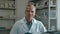 Portrait of a male pharmacist rotating on a chair and smiling at camera