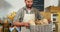 Portrait of male staff holding breads in basket at bakery section