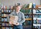 Portrait of a male student with pile books in college library