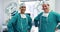 Portrait of male surgeons standing with hands on hips in operation room