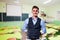 Portrait of a male teacher, empty classroom on background